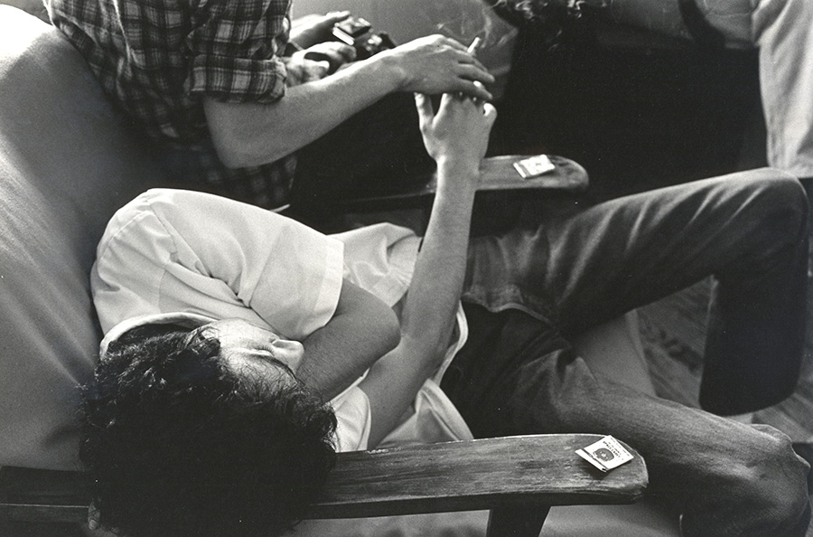 Black & White Film Photo of Sprawling Young Man Sharing a Cigarette.